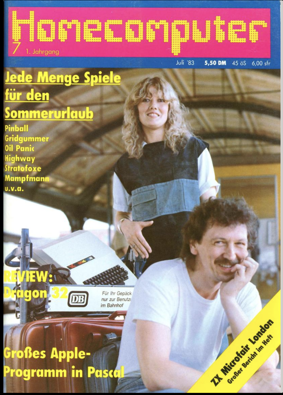 A man and woman have a good laugh sitting next to a baggage trolley on which they have suitcases and a Dragon 32 computer